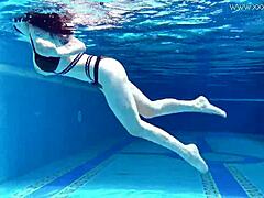 Sheril Blossom, hot Russian teen, strips underwater at beach pool. She shows shaved body in amateur public swim.